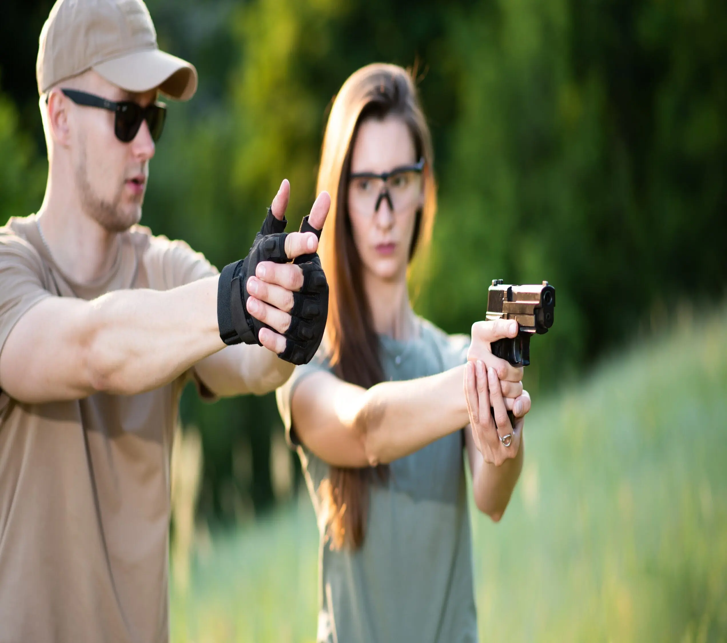 Firearms instructor coaching woman student on pistol fundamentals at the range