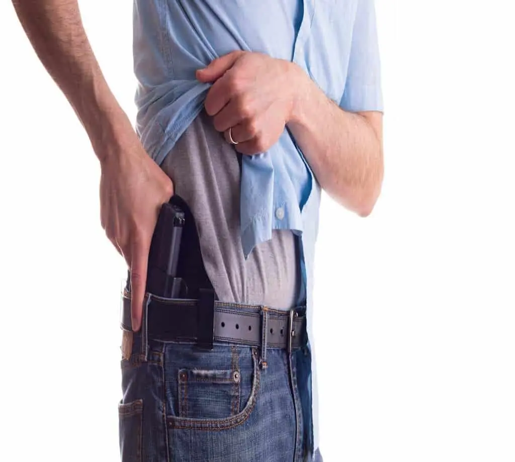 Concealed carry draw practice showing pistol drawn from under a cover garment